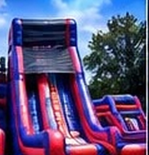 Tall blue and red inflatable double-lane slide outdoors